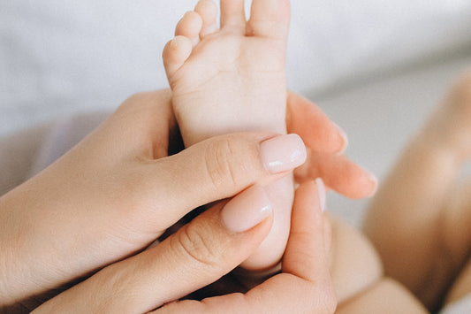 Mother holding baby foot gently - beef tallow for baby eczema natural remedy