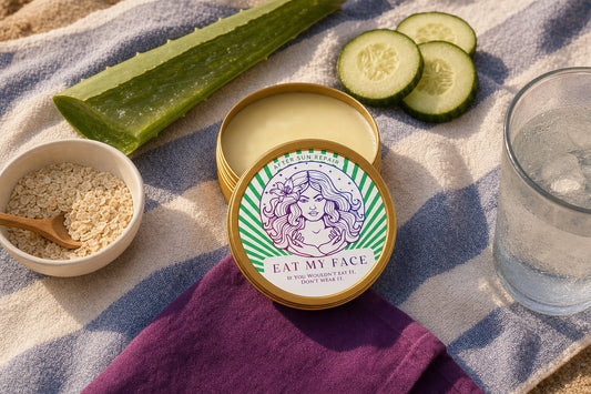 Eat My Face After Sun Repair tallow tin on a striped beach towel surrounded by aloe, cucumber slices, colloidal oatmeal, and ice water at golden hour