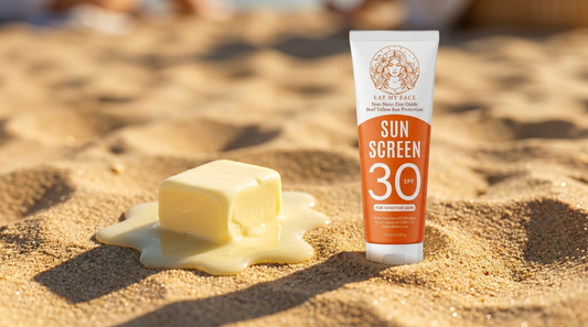 Eat My Face SPF 30 mineral sunscreen tube standing on sunny sand beside a melting pat of butter