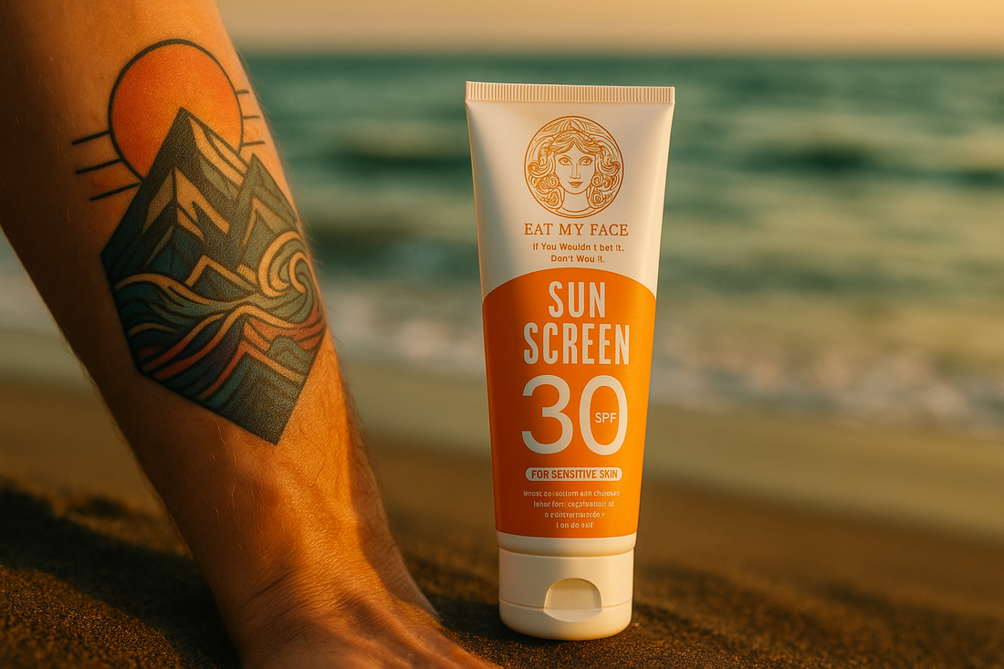 Tattooed forearm in golden-hour beach sunlight with real Eat My Face beef tallow SPF 30 travel tube on dark wet sand — protect tattoo color from UV fade
