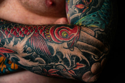 Colorful Japanese-style dragon sleeve tattoo with vibrant reds and blues — UV-sensitive ink that needs mineral sunscreen protection