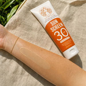 Tinted beef tallow sunscreen SPF 30 from the 2-pack rubbed in on medium-light skin, very light cocoa tint