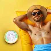 Beef Tallow After Sun Repair with Aloe & Cucumber balm tin beside sunbathing man on yellow lounge, soothing after-sun moisture relief