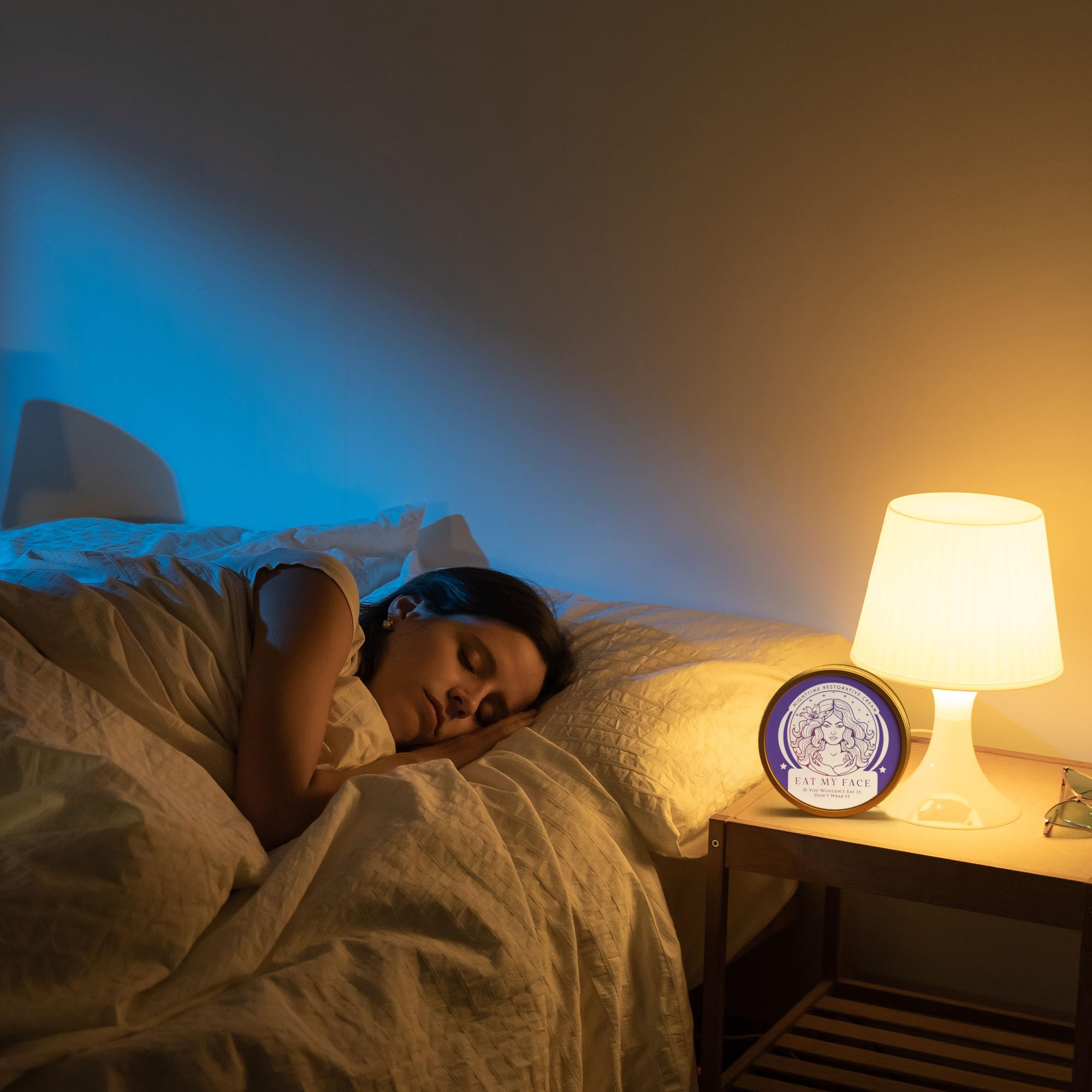 Beef Tallow Nighttime Restorative Cream with Lavender & Chamomile jar on bedside table beside lamp as woman sleeps