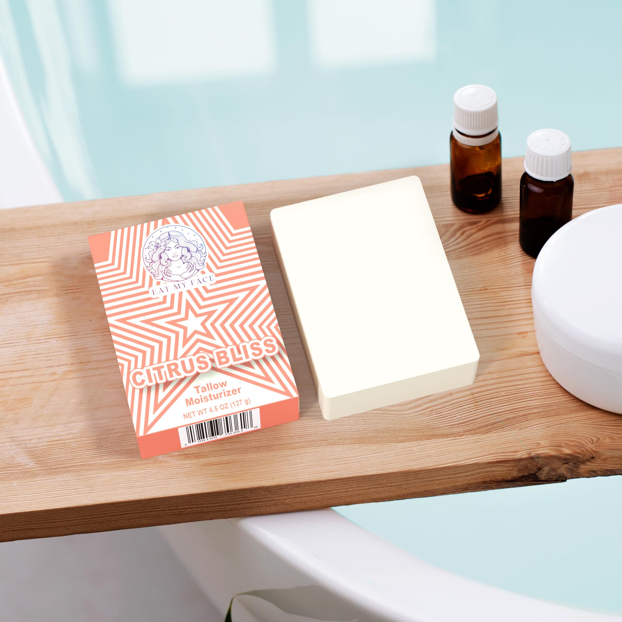 citrus tallow soap bar with Citrus Bliss label and unwrapped soap bar on wooden bath tray beside essential oil bottles