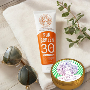 Eat My Face SPF 30 sunscreen tube and After Sun Repair balm in a towel lifestyle scene with real package artwork